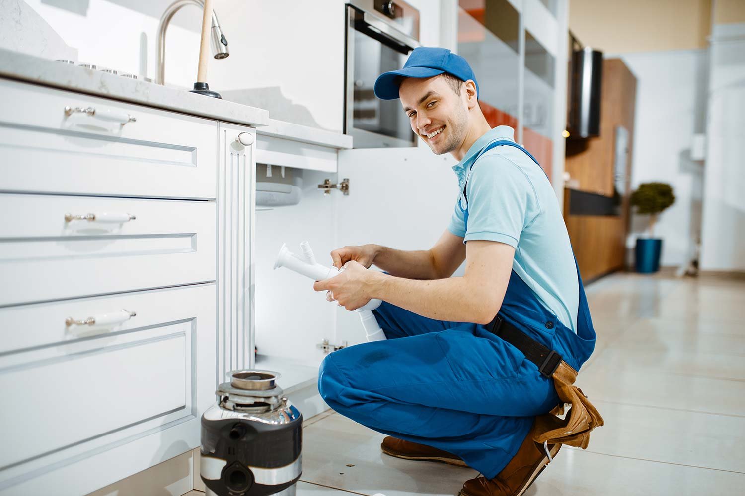 smiling-male-plumber-in-uniform-holds-drain-pipe-resize.jpg